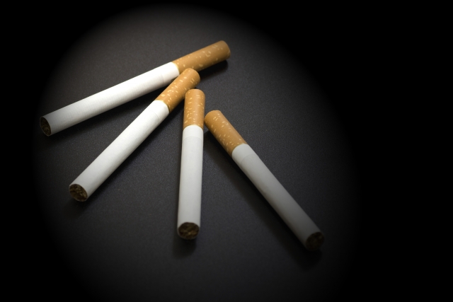 黒背景に並んでいる4本のタバコの画像